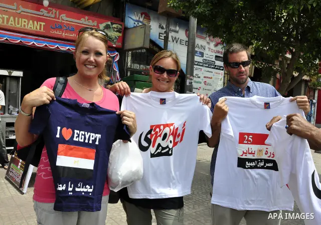 Foreign tourists buy T-shirts paint with an Egyptian flag and Arabic language words from a stall in Cairo, Egypt on May 3, 2011. Photo by Ahmed Asad
