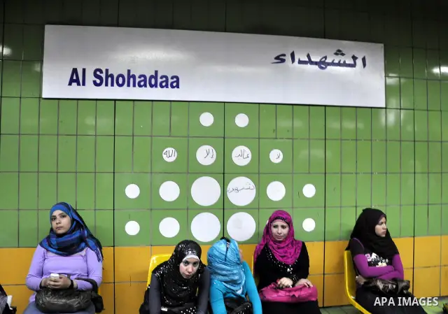 Egyptian women wait at a metro station under a placard holding the name Al Shohadaa "the Martyrs" in Arabic and English in Cairo, Egypt on May 03, 2011. Al Shohadaa is the new name of the metro which called in the past i...