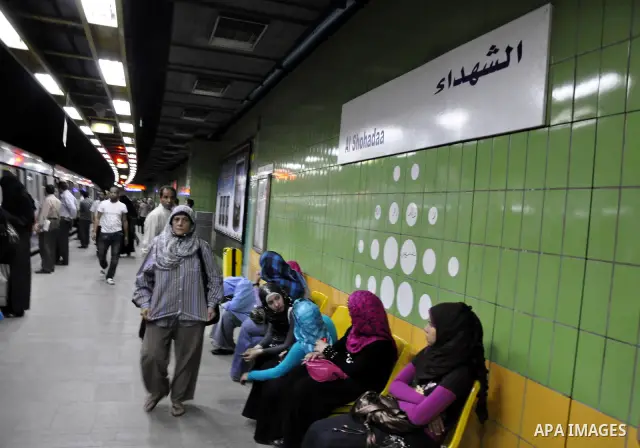 Egyptian women wait at a metro station under a placard holding the name Al Shohadaa "the Martyrs" in Arabic and English in Cairo, Egypt on May 03, 2011. Al Shohadaa is the new name of the metro which called in the past i...