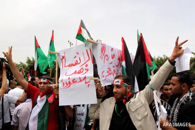 Palestinians wave with national flag and shout slogans during a rally celebrating the signing of a reconciliation deal in Gaza city on May 4,2011. Hundreds of Palestinians have gathered to cheer on a unity agreement bein...