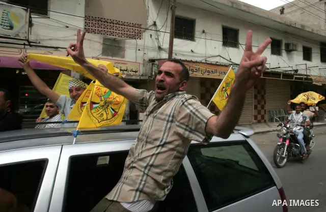 Palestinians wave with Fatah party flags during a rally celebrating the signing of a reconciliation deal in Gaza city on May 4,2011. Hundreds of Palestinians have gathered to cheer on a unity agreement being signed in Ca...