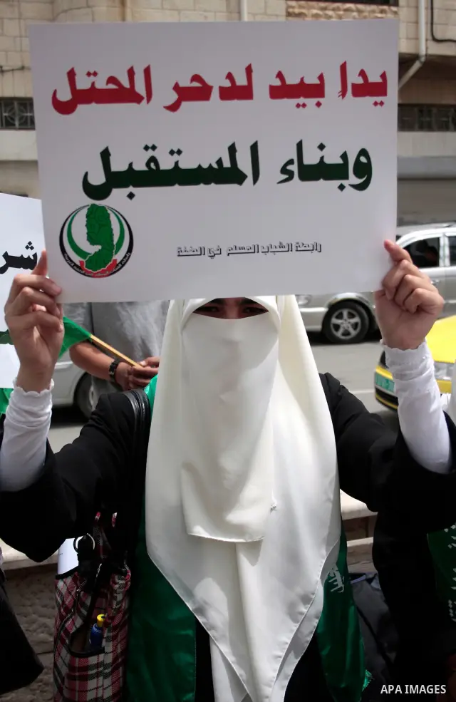 Palestinian women supporters of the Hamas Islamist movement demonstrate in the West Bank city of Hebron on May 04, 2011 as Palestinians in the West Bank and Gaza Strip gather to celebrate and welcome a reconciliation dea...