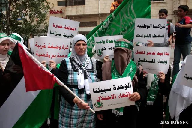 Palestinian women supporters of the Hamas Islamist movement demonstrate in the West Bank city of Hebron on May 04, 2011 as Palestinians in the West Bank and Gaza Strip gather to celebrate and welcome a reconciliation dea...