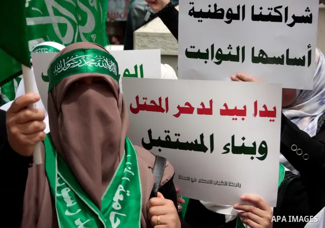 Palestinian women supporters of the Hamas Islamist movement demonstrate in the West Bank city of Hebron on May 04, 2011 as Palestinians in the West Bank and Gaza Strip gather to celebrate and welcome a reconciliation dea...