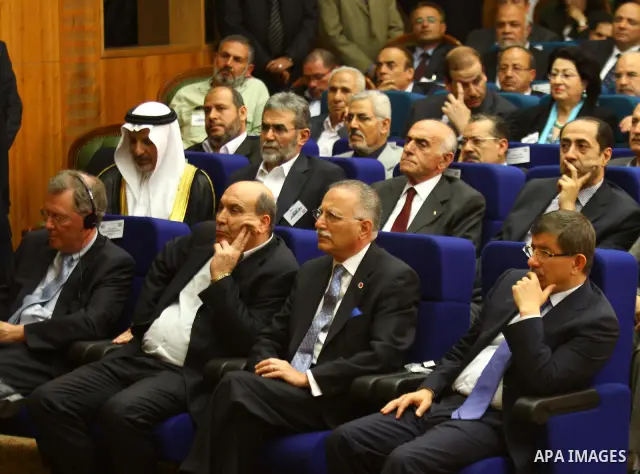 Turkish Foreign Minister Ahmet Davutoglu sits next to Ekmeleddin Ihsanoglu, secretary general of the Organisation of the Islamic Conference (OIC), during a reconciliation ceremony between the Palestinian Fatah party and...
