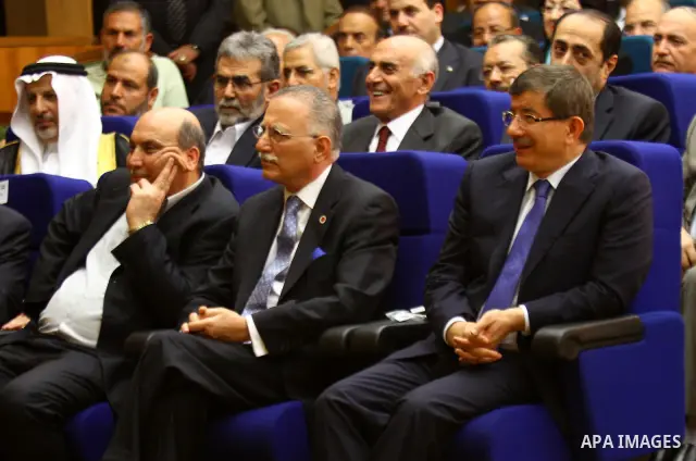 Turkish Foreign Minister Ahmet Davutoglu sits next to Ekmeleddin Ihsanoglu, secretary general of the Organisation of the Islamic Conference (OIC), during a reconciliation ceremony between the Palestinian Fatah party and...