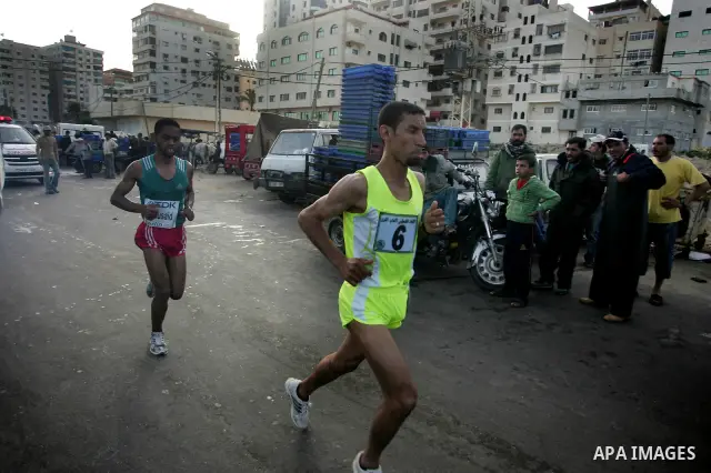 Palestinian Olympic athlete Nader Masri runs past a fish market in Gaza City on May 5, 2011 as he competes in the Gaza Strip's first-ever marathon which runs the entire length of the coastal enclave. Photo by Mohammed Ot...