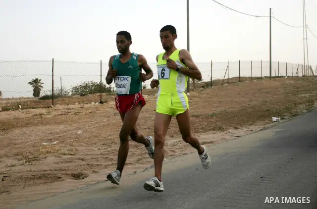 Palestinian Olympic athlete Nader Masri (R) and a fellow runner speed along the waterfront in Gaza City on May 5, 2011 as they compete in the Gaza Strip's first-ever marathon which runs the entire length of the coastal e...