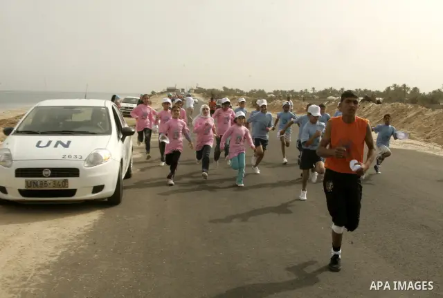 UN vehicles escort Palestinian and foreign participants running in Rafah town in the southern Gaza Strip on May 5, 2011 as they compete in the Gaza Strip's first-ever marathon which runs the entire length of the coastal...