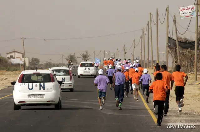 UN vehicles escort Palestinian and foreign participants running in Rafah town in the southern Gaza Strip on May 5, 2011 as they compete in the Gaza Strip's first-ever marathon which runs the entire length of the coastal...