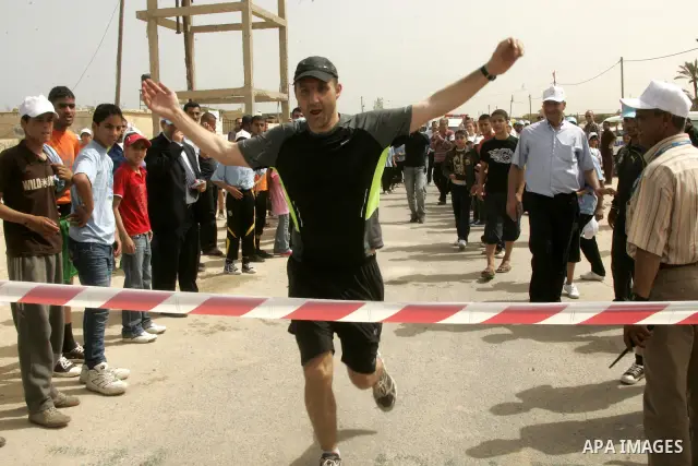 Frenchman Sebastien Trives, deputy director of UNRWA's Gaza operations, cross the finish line of Gaza Strip's first-ever marathon on May 5, 2011 in Rafah, southern Gaza Strip. More than 1,400 Palestinians were up before...