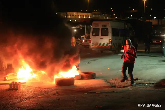 Masked Palestinian youths throw stones during clashes with Israeli police in the flashpoint east Jerusalem's Shu'fat refugee camp on May 5, 2011. Photo by Sliman Khader