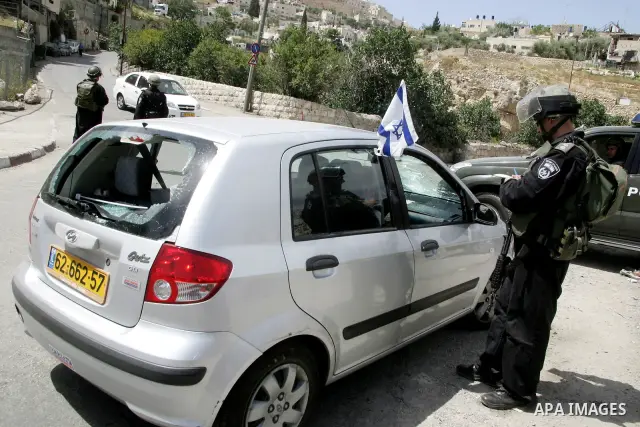 Israeli soldiers inspect the broken glass in a jewish settler car which damaged by Palestinian stone-throwers during clashes in the flashpoint east Jerusalem neighbourhood of Silwan on May 6,2011. Photo by Mahfouz Abu Tu...