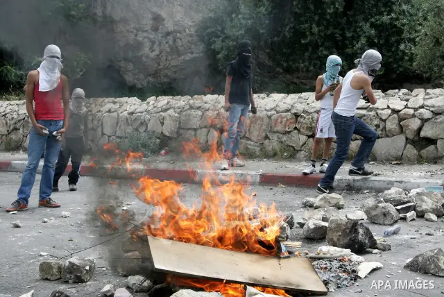 Palestinian youths prepare to hurl stones toward Israeli soldiers during clashes in the flashpoint east Jerusalem neighbourhood of Silwan on May 6,2011. Photo by Mahfouz Abu Turk