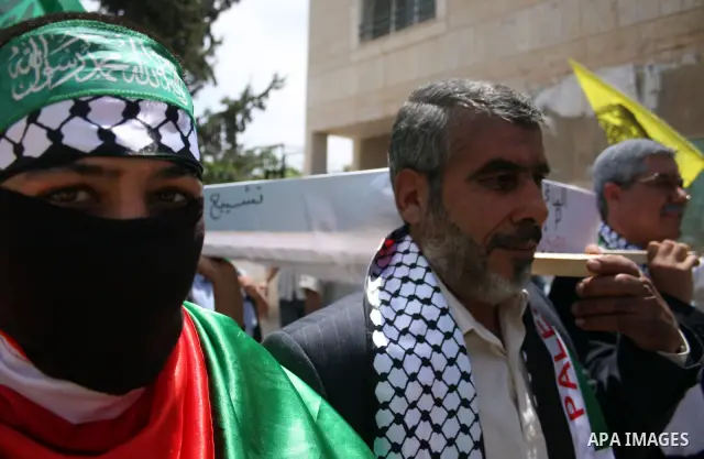 Look alikes of Palestinian Authority President Mahmud Abbas (R) and Hamas leader Khaled Meshaal carry a mock coffin representing the death of the Palestinian political division during a rally by supporters of Abbas' Fata...