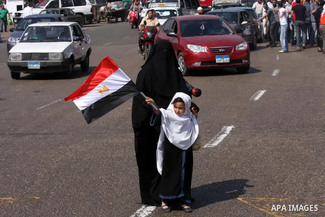 An Egyptian girl holds a national flag as Islamists march to the US embassy after the weekly Friday prayer in Cairo on May 6, 2011, during a demonstration to denounce the killing of Osama bin Laden by US forces in Pakist...
