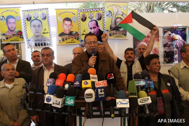 Palestinians Speak during a press conference, as women hold pictures of jailed relatives during a protest in Gaza city calling for their release from Israeli prisons on May 7, 2011. Photo by Mohamad Asad