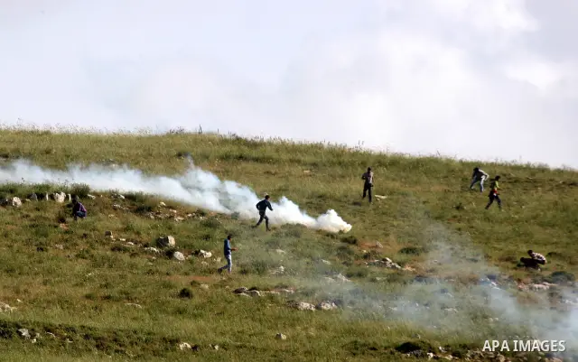 Palestinian youths run in tear gas as they clash with Israeli soldiers during a demonstrate against Jewish settlements in the northern West Bank village of Iraq Burin on May 7, 2011. Photo by Wagdi Eshtayah
