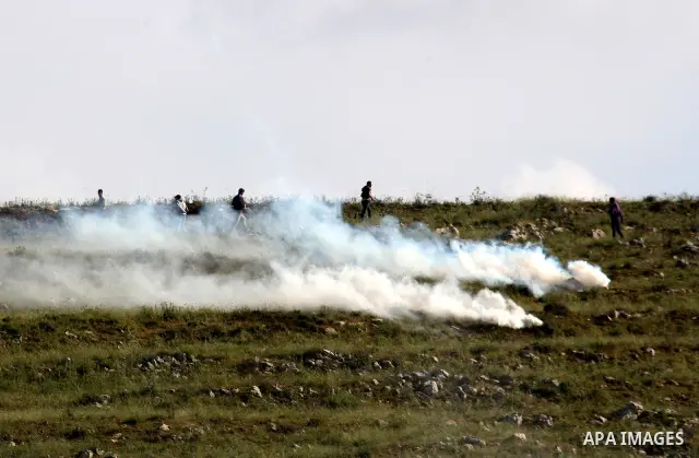 Palestinian youths run in tear gas as they clash with Israeli soldiers during a demonstrate against Jewish settlements in the northern West Bank village of Iraq Burin on May 7, 2011. Photo by Wagdi Eshtayah