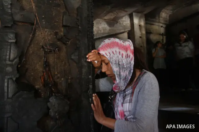 An Egyptians Christian woman reacts at the damaged Virgin Mary church in the popular area of Imbaba in the Egyptian capital of Cairo on May 8, 2011, after overnight clashes between Muslims and Christians which left 10 pe...