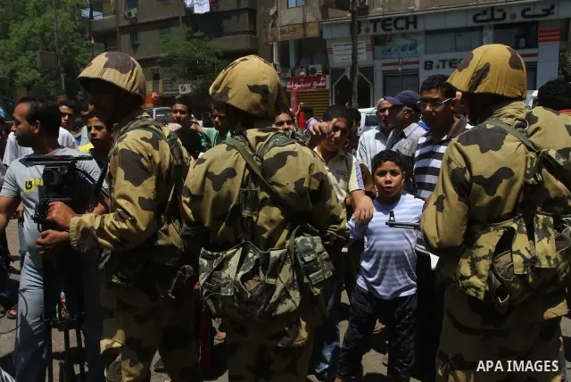 Egyptian military soldiers stand guard as Christians remove objects from the Virgin Mary church in the popular area of Imbaba in the Egyptian capital of Cairo on May 8, 2011 after clashes between Muslims and Christians w...