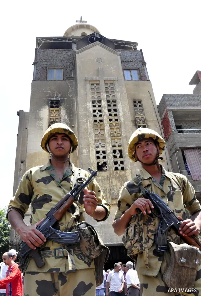Egyptian military soldiers stand guard as Christians remove objects from the Virgin Mary church in the popular area of Imbaba in the Egyptian capital of Cairo on May 8, 2011 after clashes between Muslims and Christians w...