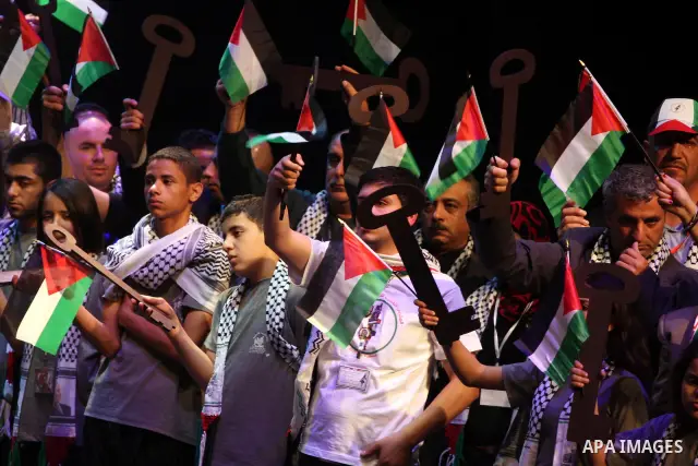 Palestinians hold flags and symbolic keys during a celebration in the West Bank city of Ramallah, Sunday, May 8, 2011 to commemorate the 63rd anniversary of Nakba, or catastrophe, the Arabic term used to describe the upr...