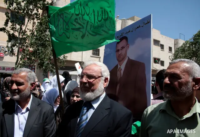 Palestinian parliament speaker Dr, Aziz Dweik and Hamas members of the Palestinian Legislative Council (PLC) take part with Palestinian women supporters of the Hamas Islamist movement during a rally calling for the relea...
