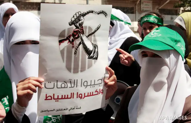 Palestinian women supporters of the Hamas Islamist movement take part in a rally calling for the release of Palestinians being held in West Bank and Gaza Strip jails in the West Bank city of Hebron on May 10, 2011. Photo...