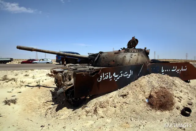 A burnt tank is seen as Libyan rebel fighters head towards the front line outside the Libyan eastern city Ajdabiya on May 10, 2011, where fighting between rebels and forces loyal to leader Moamer Kadhafi is ongoing. Phot...