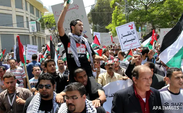 Palestinians hold their national flag and chant slogans during a rally in Gaza city on May 11,2011 calling Fatah and Hamas movements to unit and deal with reconciliation agreement. Photo by Mohammed Asad