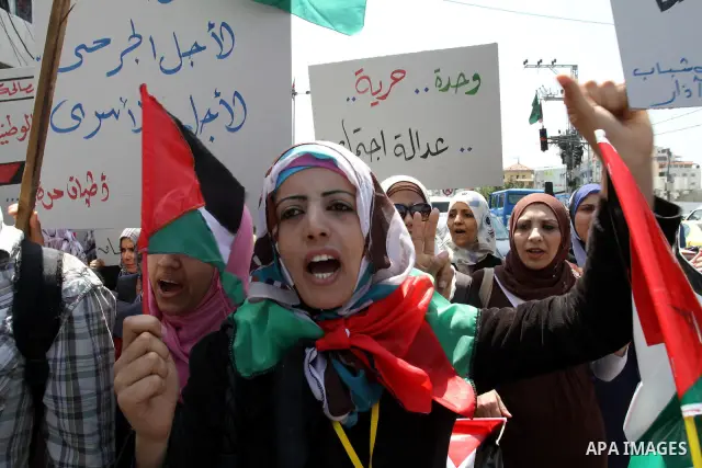 Palestinians hold their national flag and chant slogans during a rally in Gaza city on May 11,2011 calling Fatah and Hamas movements to unit and deal with reconciliation agreement. Photo by Mohammed Asad
