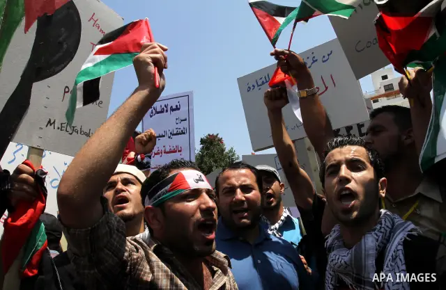 Palestinians hold their national flag and chant slogans during a rally in Gaza city on May 11,2011 calling Fatah and Hamas movements to unit and deal with reconciliation agreement. Photo by Mohammed Asad