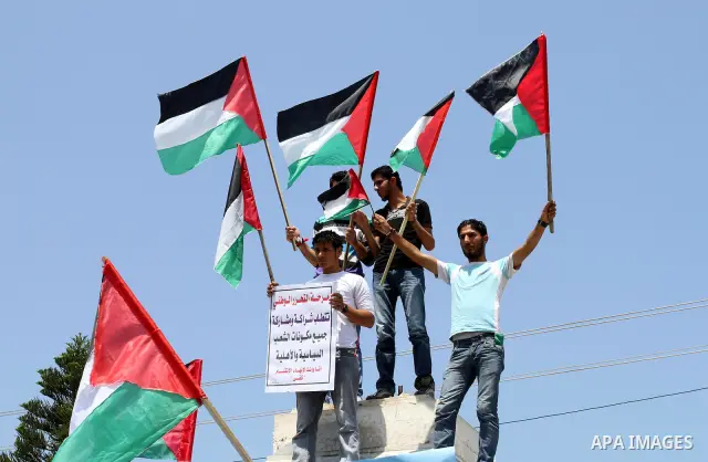 Palestinians hold their national flag and chant slogans during a rally in Gaza city on May 11,2011 calling Fatah and Hamas movements to unit and deal with reconciliation agreement. Photo by Mohammed Asad