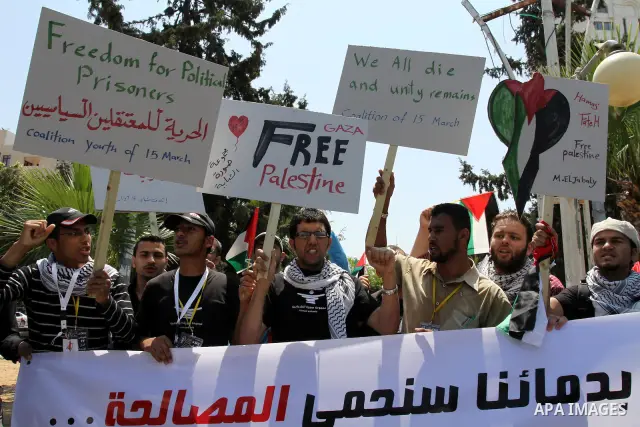 Palestinians hold their national flag and chant slogans during a rally in Gaza city on May 11,2011 calling Fatah and Hamas movements to unit and deal with reconciliation agreement. Photo by Mohammed Asad