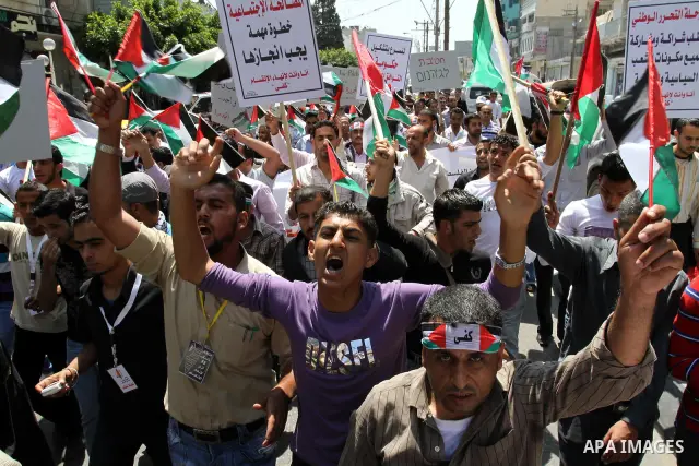 Palestinians hold their national flag and chant slogans during a rally in Gaza city on May 11,2011 calling Fatah and Hamas movements to unit and deal with reconciliation agreement. Photo by Mohammed Asad
