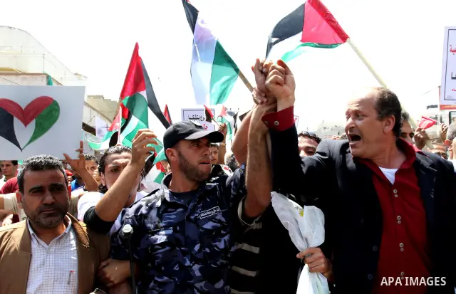 Palestinians hold their national flag and chant slogans during a rally in Gaza city on May 11,2011 calling Fatah and Hamas movements to unit and deal with reconciliation agreement. Photo by Mohammed Asad