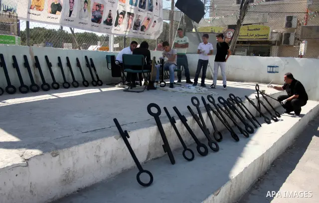 Palestinians paint slogans on keys symbolizing the homes people lost in 1948 when the Jewish state of Israel was created, on May 11, 201 in the West Bank Qalandia refugee camp near Jerusalem, during a preparation to mark...