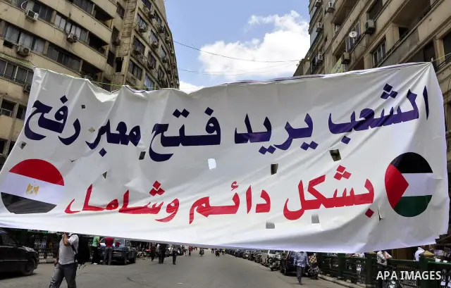 Egyptian demonstrators hold signs during a rally at Cairo's Tahrir Square on May 13, 2011 during a protest calling for national unity after attacks on Egyptian churches, and solidarity with the Palestinians as they mark...