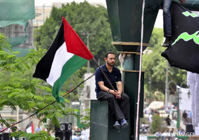 Egyptian demonstrators wave a Palestinian flag during a rally at Cairo's Tahrir Square on May 13, 2011 during a protest calling for national unity after attacks on Egyptian churches, and solidarity with the Palestinians...