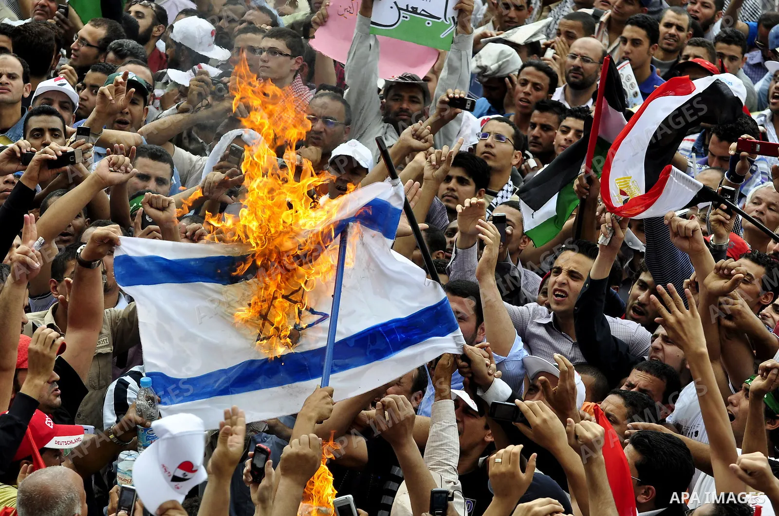 Egyptian demonstrators set fire in an Israeli flag during a rally at Cairo's Tahrir Square on May 13, 2011 during a protest calling for national unity after attacks on Egyptian churches, and solidarity with the Palestini...