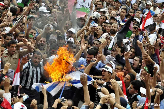 Egyptian demonstrators set fire in an Israeli flag during a rally at Cairo's Tahrir Square on May 13, 2011 during a protest calling for national unity after attacks on Egyptian churches, and solidarity with the Palestini...