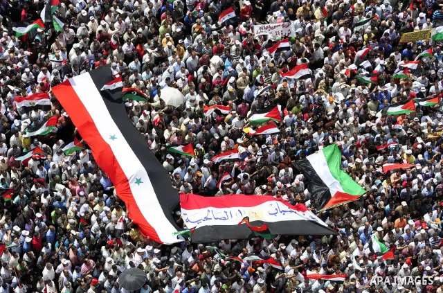 Egyptian demonstrators wave Palestinian flags and Egyptian flags during a rally at Cairo's Tahrir Square on May 13, 2011 during a protest calling for national unity after attacks on Egyptian churches, and solidarity with...
