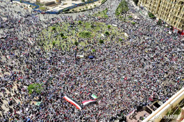 Egyptian demonstrators wave Palestinian flags and Egyptian flags during a rally at Cairo's Tahrir Square on May 13, 2011 during a protest calling for national unity after attacks on Egyptian churches, and solidarity with...