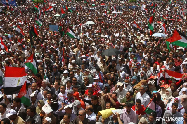 Egyptian demonstrators wave Palestinian flags and Egyptian flags during a rally at Cairo's Tahrir Square on May 13, 2011 during a protest calling for national unity after attacks on Egyptian churches, and solidarity with...