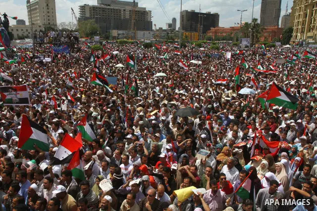 Egyptian demonstrators wave Palestinian flags and Egyptian flags during a rally at Cairo's Tahrir Square on May 13, 2011 during a protest calling for national unity after attacks on Egyptian churches, and solidarity with...