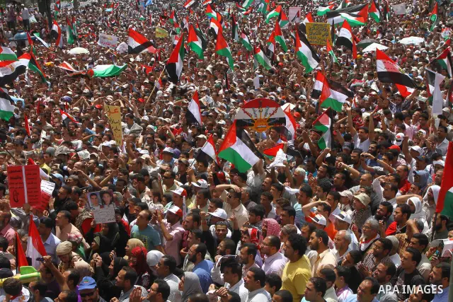 Egyptian demonstrators wave Palestinian flags and Egyptian flags during a rally at Cairo's Tahrir Square on May 13, 2011 during a protest calling for national unity after attacks on Egyptian churches, and solidarity with...