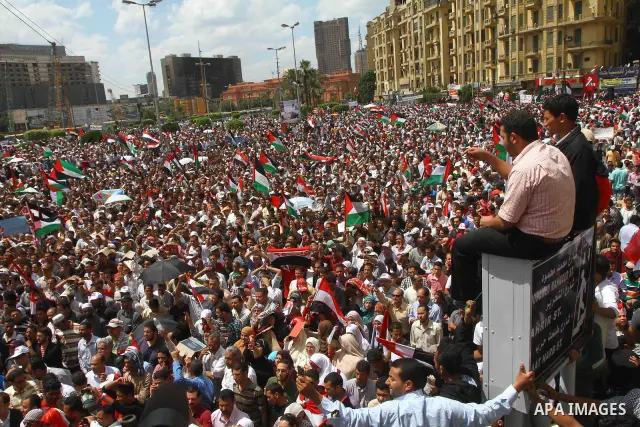 Egyptian demonstrators wave Palestinian flags and Egyptian flags during a rally at Cairo's Tahrir Square on May 13, 2011 during a protest calling for national unity after attacks on Egyptian churches, and solidarity with...