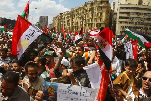 Egyptian demonstrators wave Palestinian flags and Egyptian flags during a rally at Cairo's Tahrir Square on May 13, 2011 during a protest calling for national unity after attacks on Egyptian churches, and solidarity with...