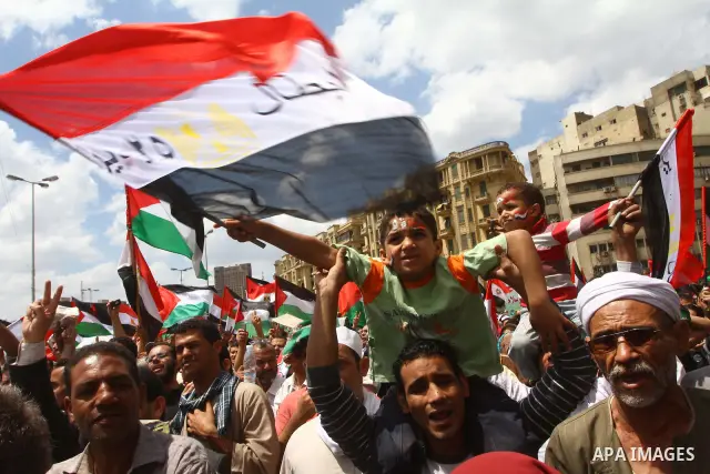 Egyptian demonstrators wave Palestinian flags and Egyptian flags during a rally at Cairo's Tahrir Square on May 13, 2011 during a protest calling for national unity after attacks on Egyptian churches, and solidarity with...